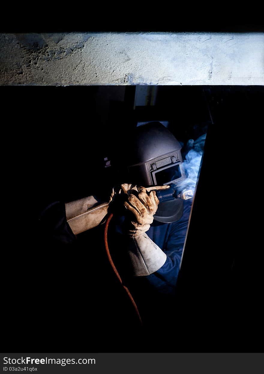 Welder at work in factory