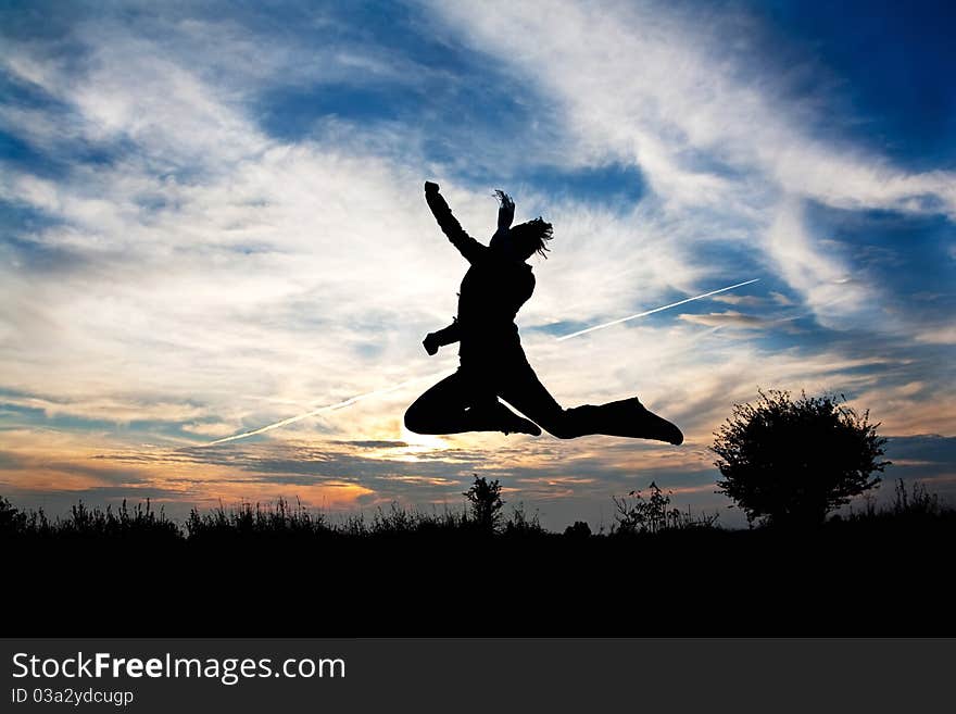 Jumping woman in nature over beautiful sunset symbolizing freedom and pleasure from life. Jumping woman in nature over beautiful sunset symbolizing freedom and pleasure from life