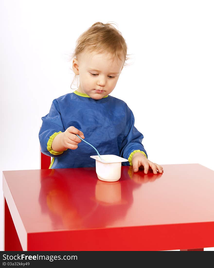 Little baby is eating on red table