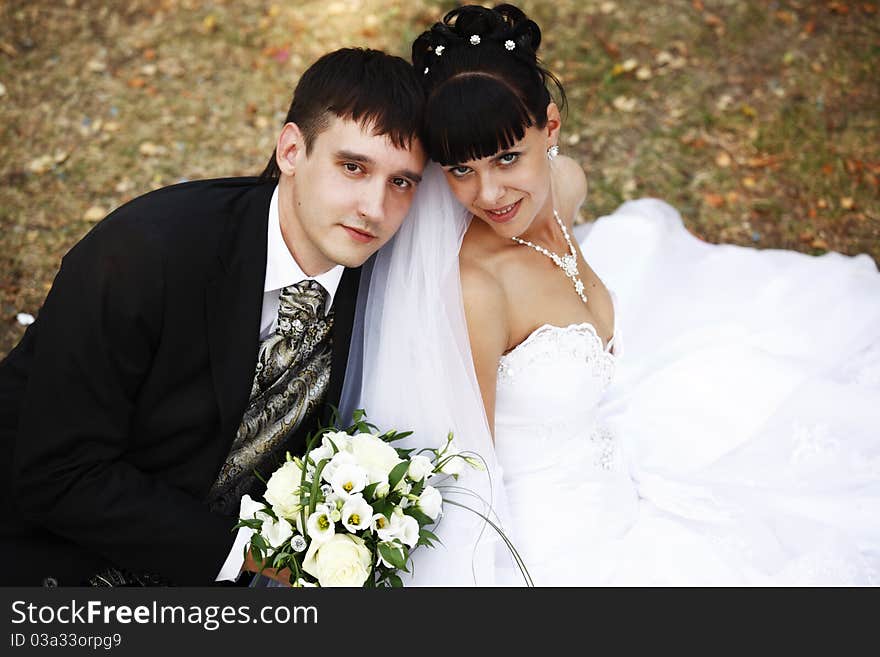 Groom and bride sitting on the ground