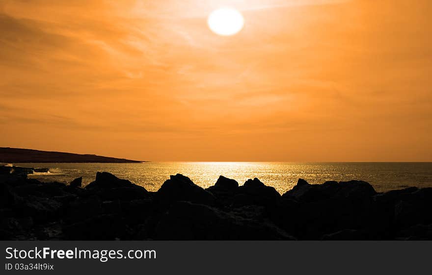 Golden sunset from the cliffs edge on a rocky landscape of the burren in county clare ireland. Golden sunset from the cliffs edge on a rocky landscape of the burren in county clare ireland