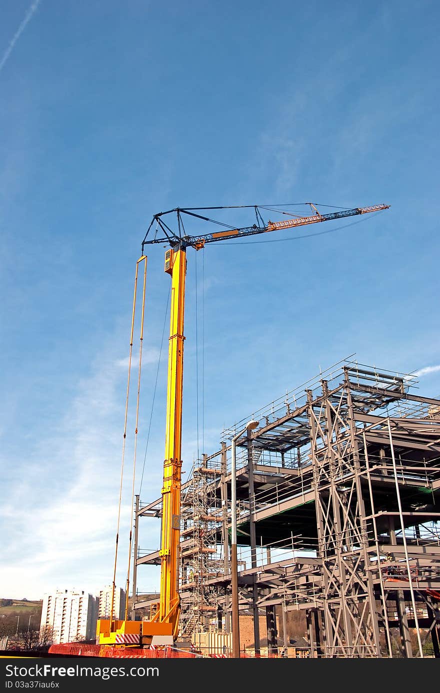 Yellow Tower Crane and Steelframed Building. Yellow Tower Crane and Steelframed Building