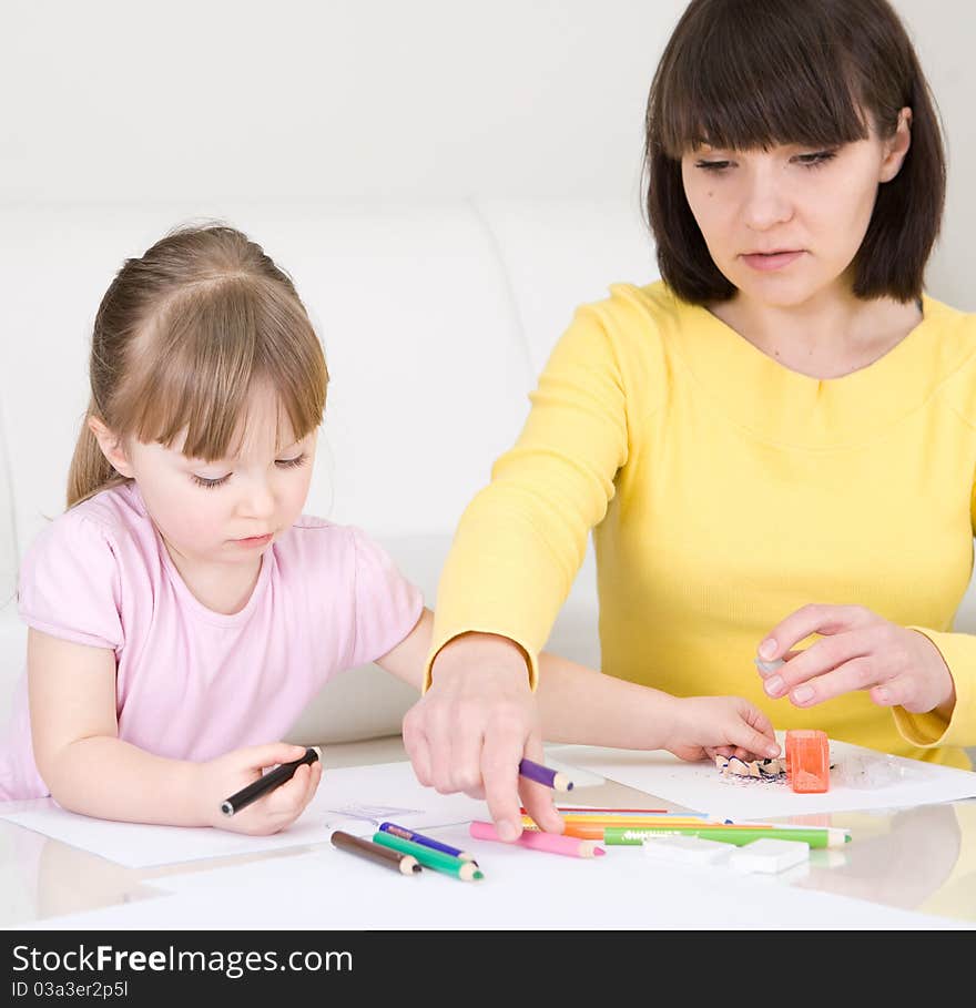 Young mother and her daughter having fun in kindergarden