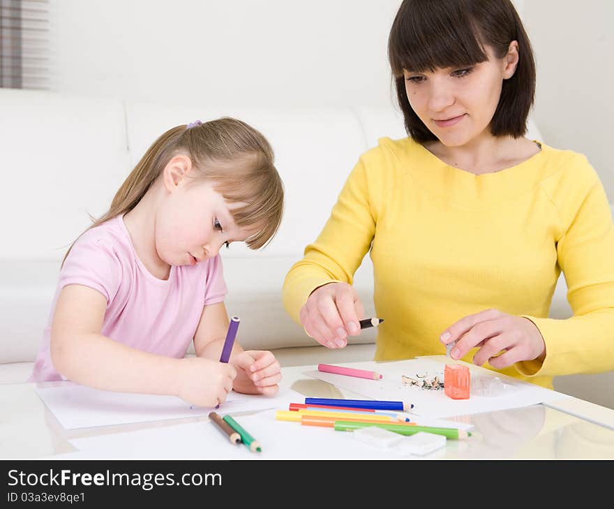 Young mother and her daughter having fun in kindergarden