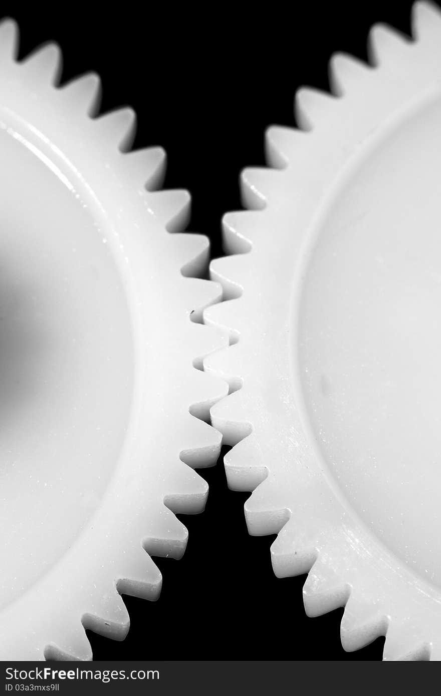 Two white connected cogwheels on black background. Two white connected cogwheels on black background