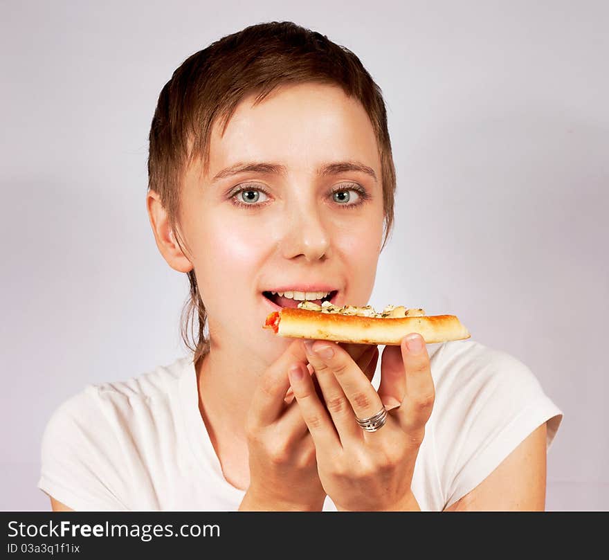 Young woman eating pizza on gray backgrounde. Young woman eating pizza on gray backgrounde