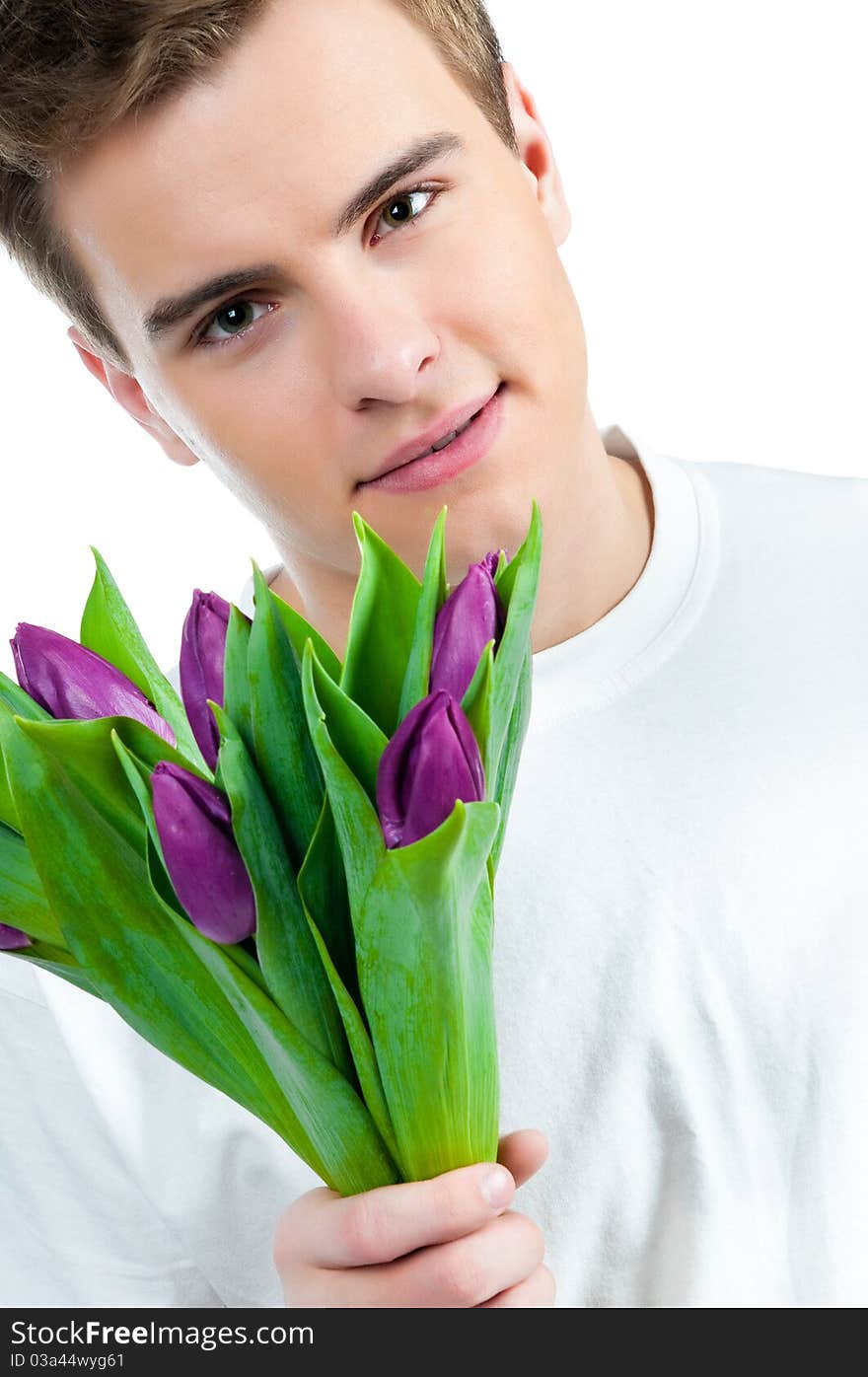 Handsome young man with a bouquet of tulips