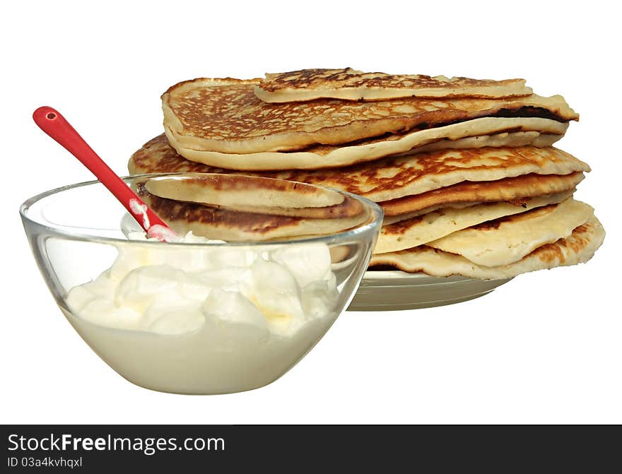 Pancakes and bowl with sour cream isolated on a white background. Pancakes and bowl with sour cream isolated on a white background