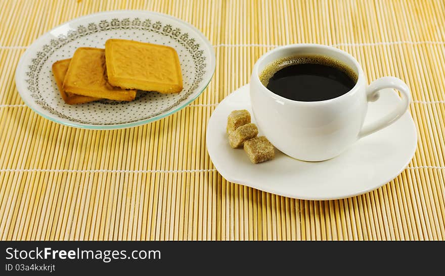 Cup of coffee and biscuits on a plate stand on a napkin reed. Cup of coffee and biscuits on a plate stand on a napkin reed