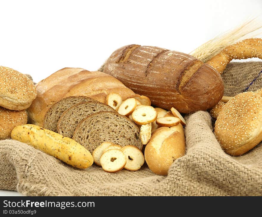 Various types of bread and other wheat products in a burlap background