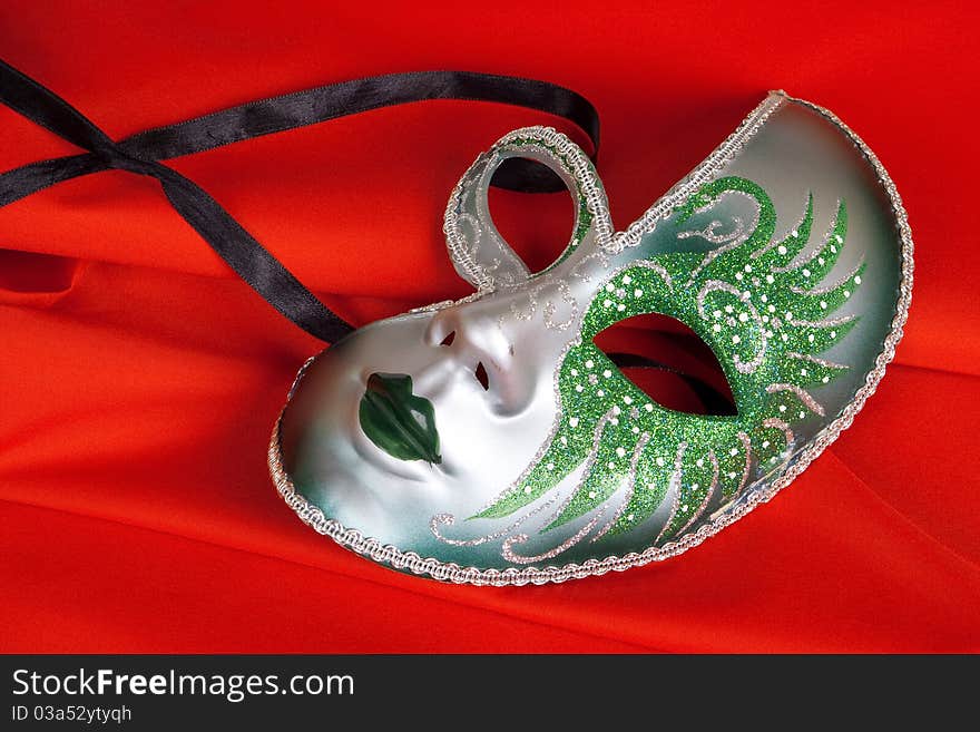 Carnival mask lying on a red, the tissue background