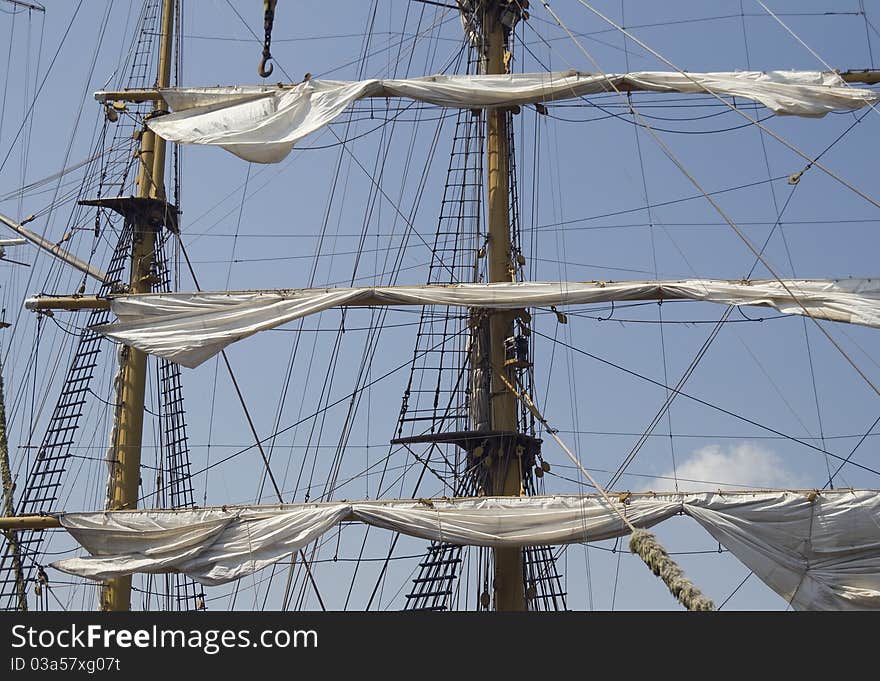 Mast of a tall ship with half-hoisted sails