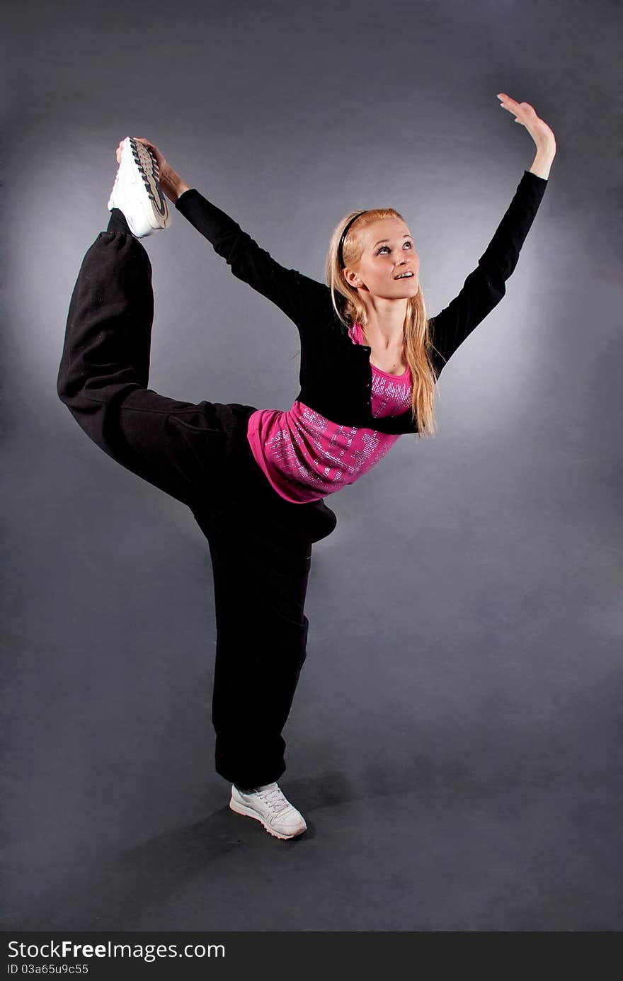 Modern style dancer posing over grey