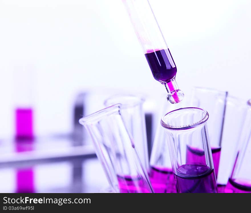 Studio photo of pipette with purple liquid samples. Studio photo of pipette with purple liquid samples