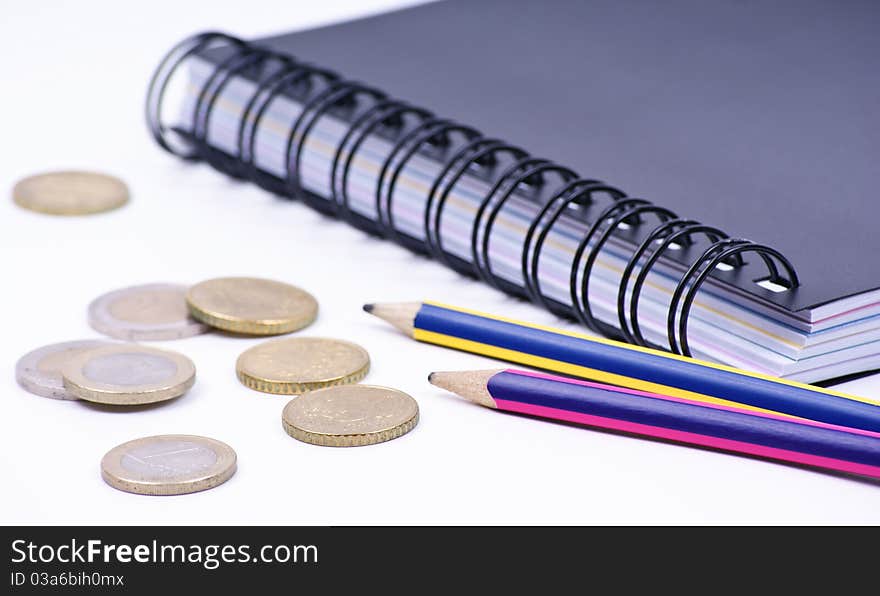 Notebook with pencils and coins