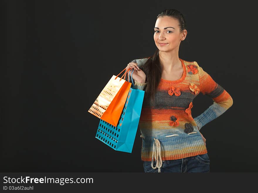 Young elegant female in sweater holding paper-bags with purchases. Young elegant female in sweater holding paper-bags with purchases