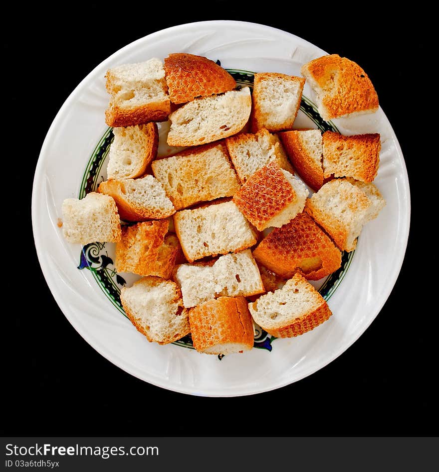 Bread rusk in a small platel isolated on black