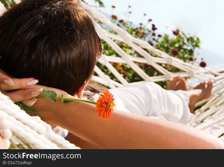 Young woman in hammock, focus on the flower (shallow dof)