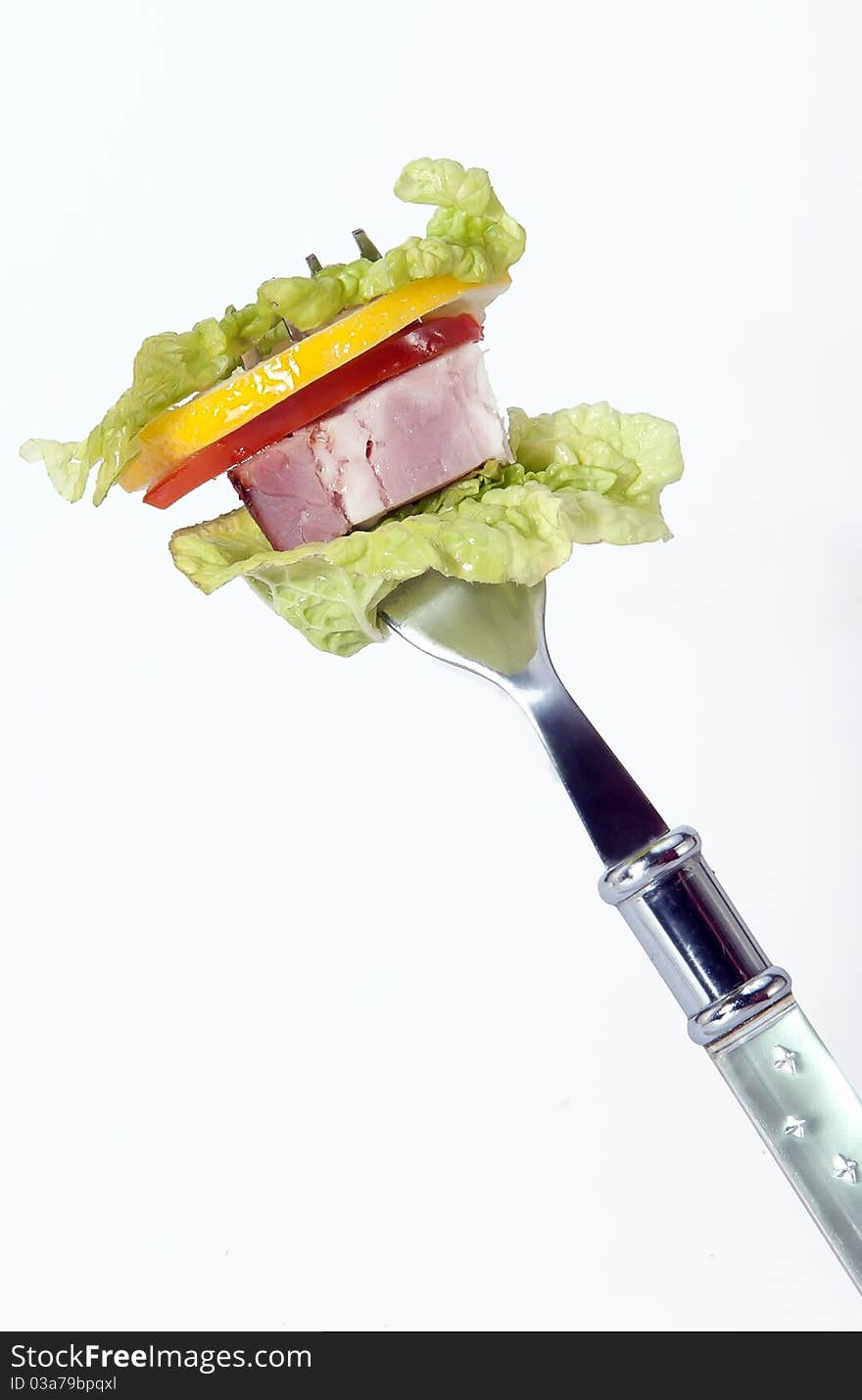 Slices salad, Ham, lemon, tomato cleared on a plug isolated on a white background. Slices salad, Ham, lemon, tomato cleared on a plug isolated on a white background