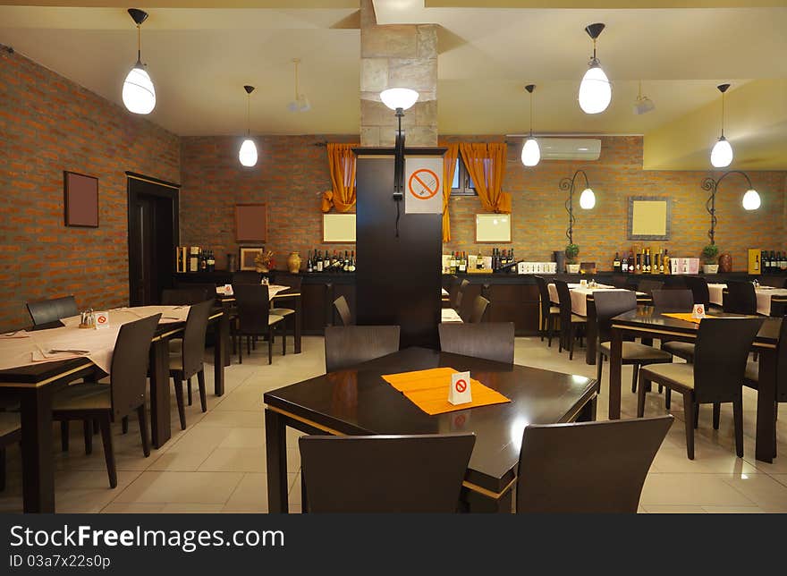 Tables, chairs, brick wall and lighting equipment of a restaurant. Tables, chairs, brick wall and lighting equipment of a restaurant.