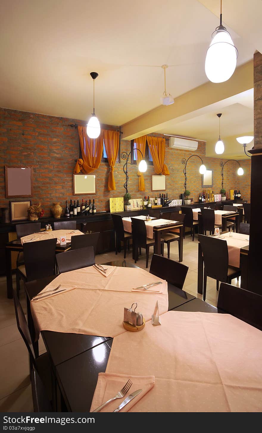 Tables, chairs, brick wall and lighting equipment of a restaurant. Tables, chairs, brick wall and lighting equipment of a restaurant.