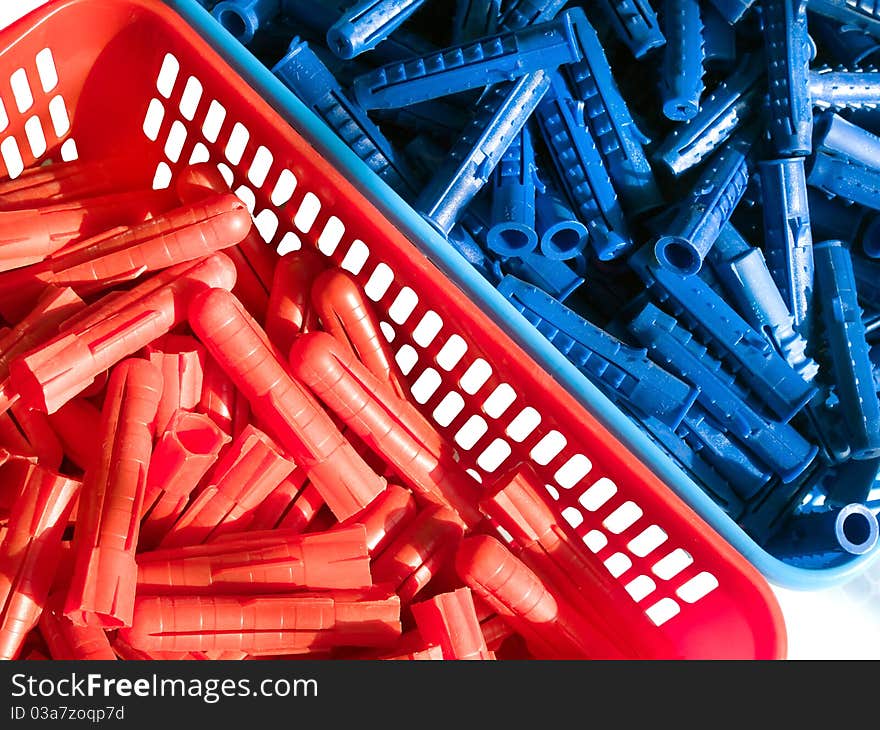 Blue and red plastic wall plugs in the boxes