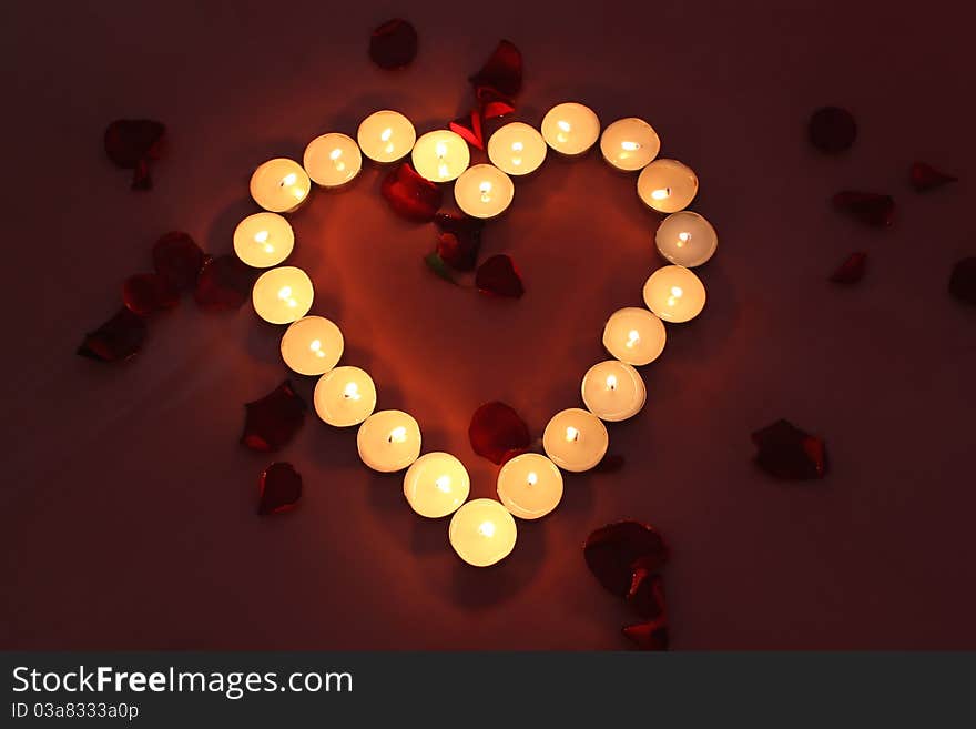 Heart of candles with rose petals. Heart of candles with rose petals