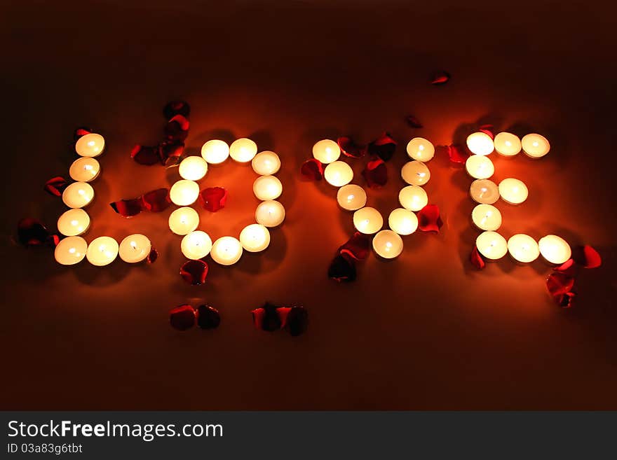 Letters of candles with rose petals. Letters of candles with rose petals