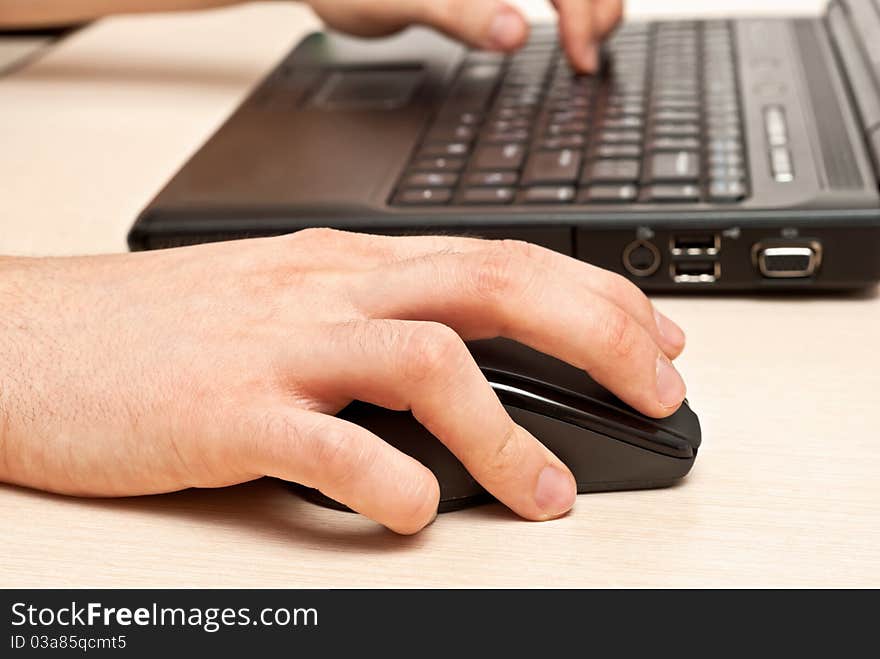 Male hands typing on a laptop keyboard. Male hands typing on a laptop keyboard