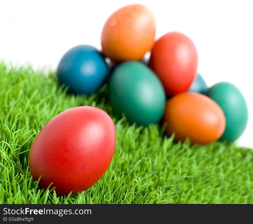 Colorful Easter eggs on green grass, with copy space