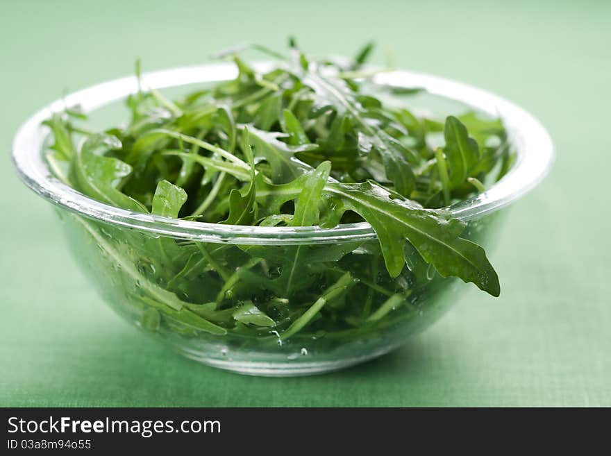 Green rucola fresh salad in glass bowl