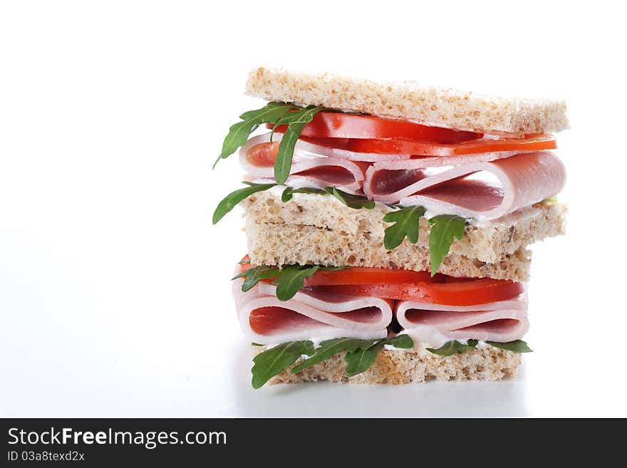 Sandwich with ham,tomato, and rucola salad on white