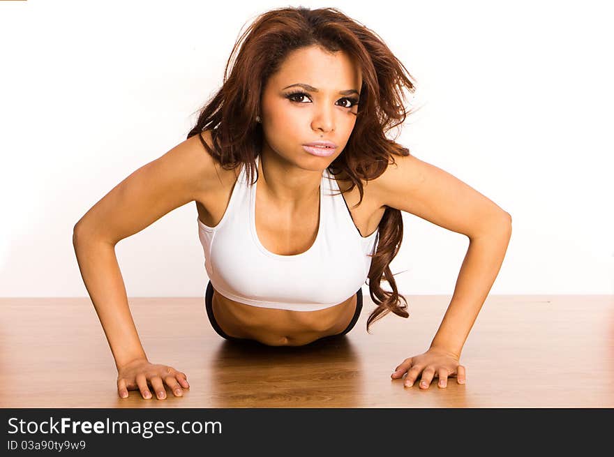 Young Woman Doing Pushups isolated on white. Young Woman Doing Pushups isolated on white