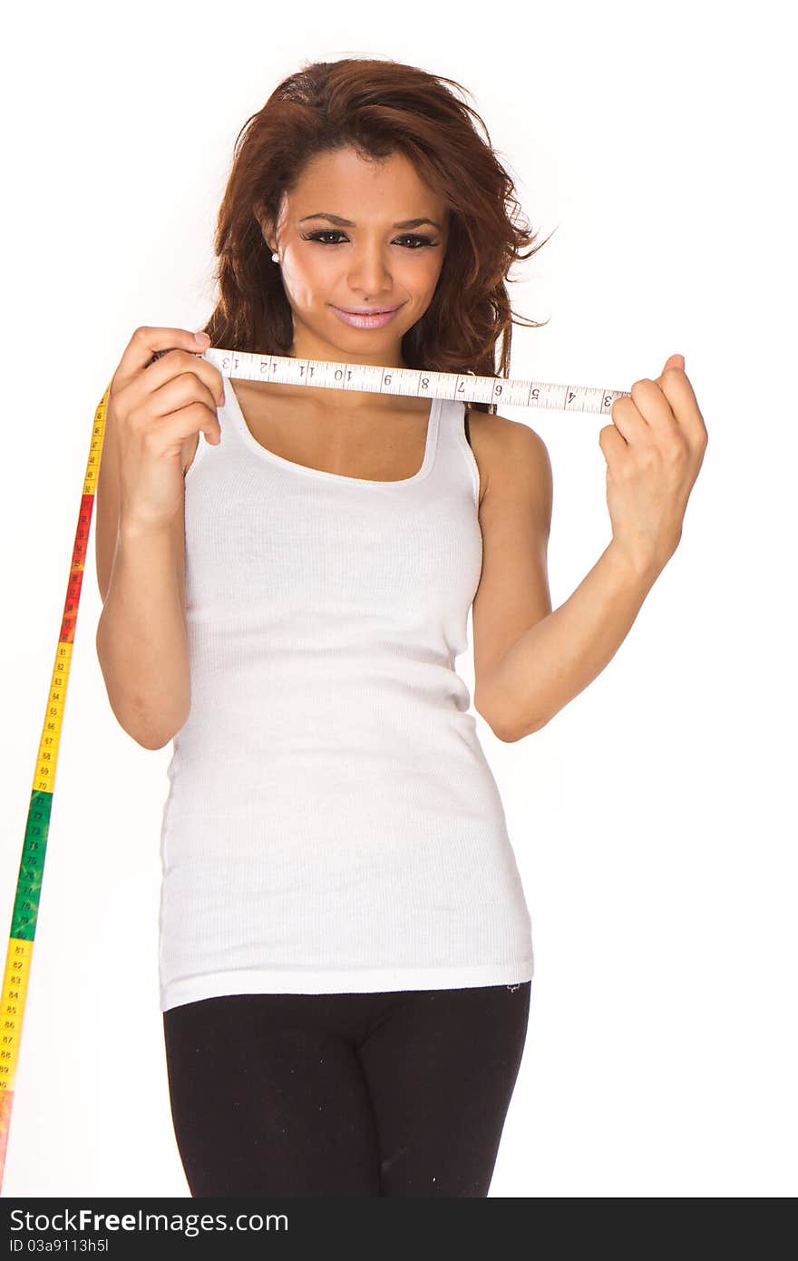 An isolated shot of a healthy brunette woman measuring her waistline and giving a thumbs up. An isolated shot of a healthy brunette woman measuring her waistline and giving a thumbs up