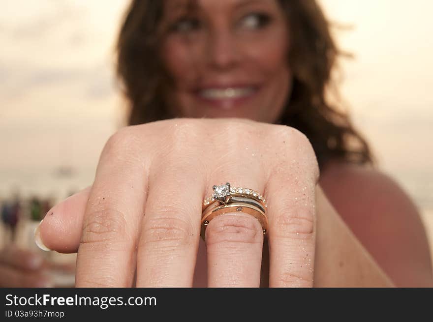 Beach wedding with bride,showing off ring