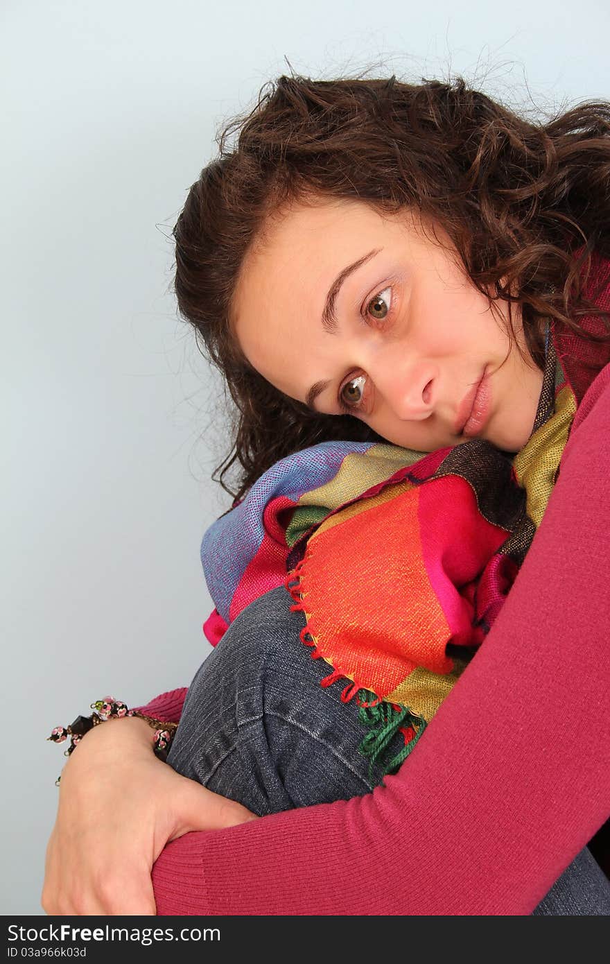 Brunette female wearing a pink top and colorful scarf