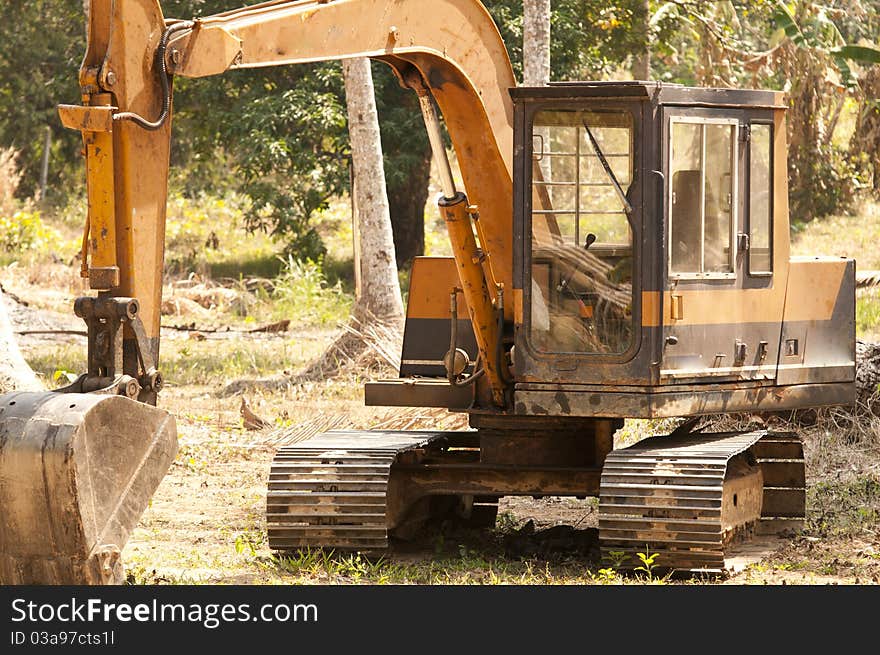 Digger in the jungle clearing trees