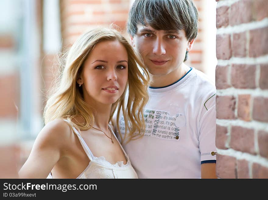 Young lovers stand together among the brick walls of an ancient palace. Young lovers stand together among the brick walls of an ancient palace