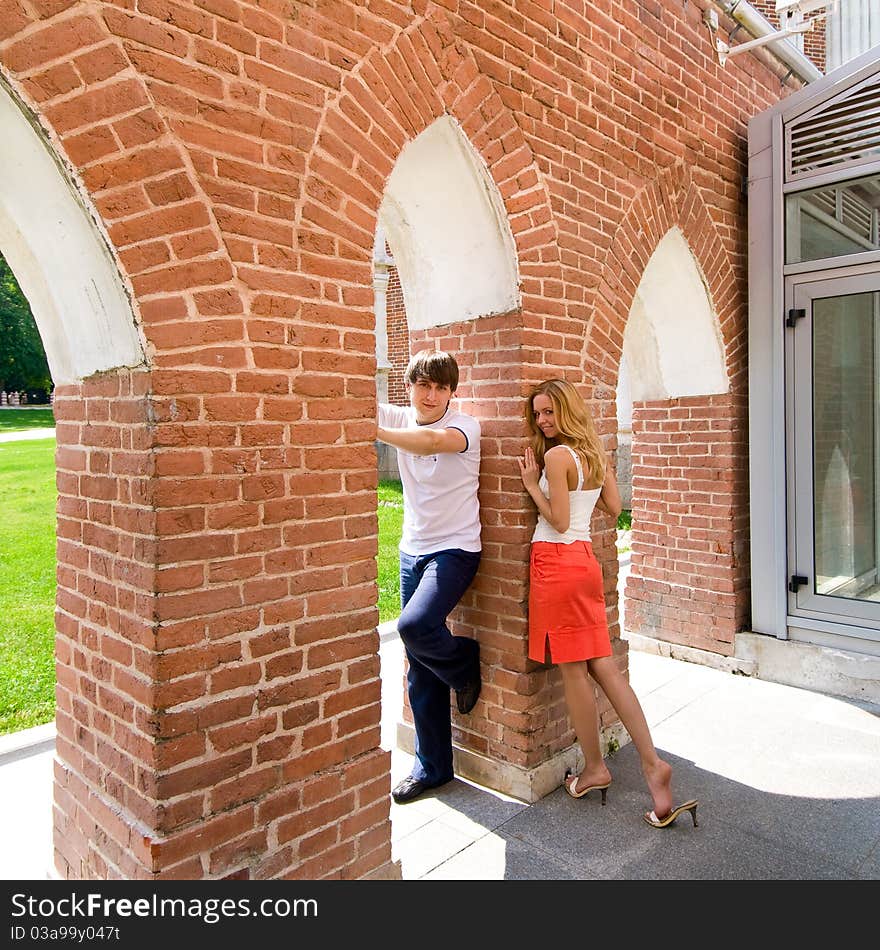 Young boy and girl standing in a full-length under the arches of brick gallery. Young boy and girl standing in a full-length under the arches of brick gallery