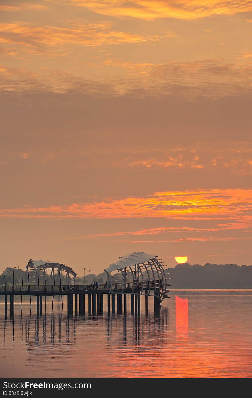 Sunrise behind a pier