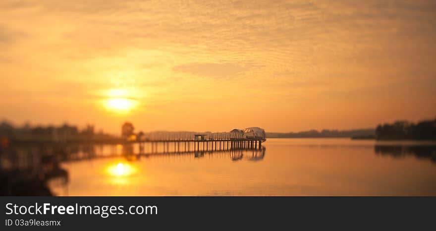 Dawn breaking from behind a uniquely shaped pier taken with a tilt shift lens to replicate a miniature architectural model. Dawn breaking from behind a uniquely shaped pier taken with a tilt shift lens to replicate a miniature architectural model