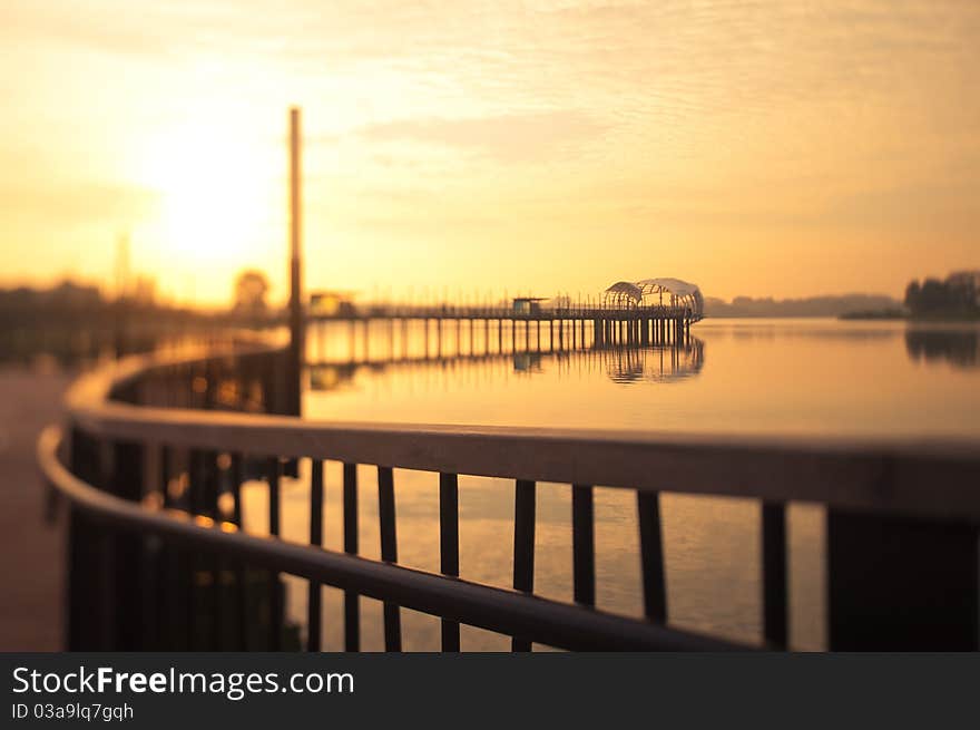 Dawn breaking from behind a uniquely shaped pier taken with a tilt shift lens to replicate a miniature architectural model. Dawn breaking from behind a uniquely shaped pier taken with a tilt shift lens to replicate a miniature architectural model