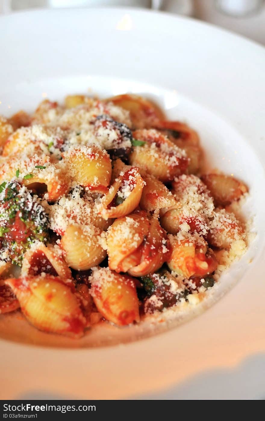 Closeup of Italian style tomato base pasta topped with spices. Closeup of Italian style tomato base pasta topped with spices.