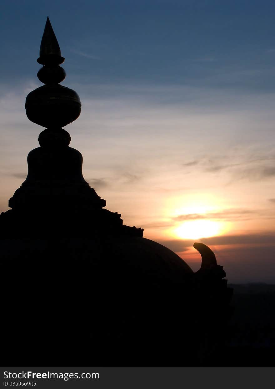 A temple dome silhouetted by the sunset.