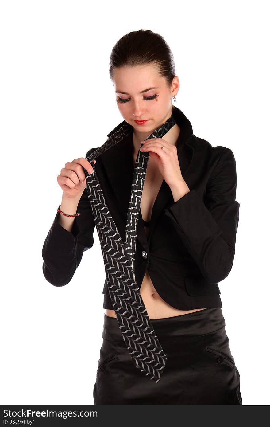 Girl in black suit makes necktie.