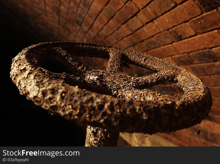 Rusty valve in underground waste system.