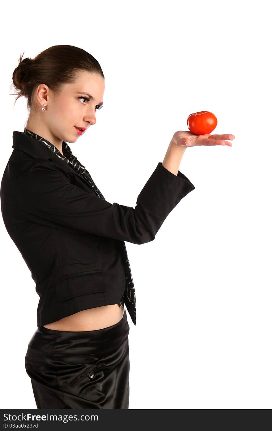 Girl in black suit looks at tomato.