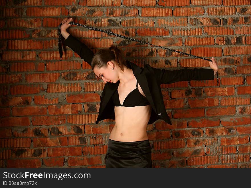 Girl in black suit tuck necktie above head.