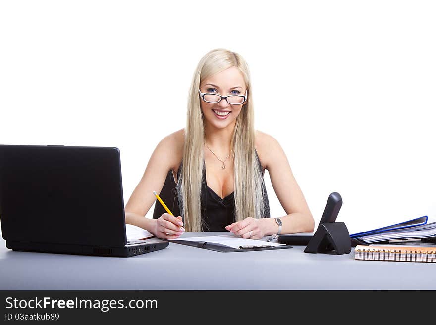 Happy businesswoman sitting at office desk, smiling. Isolated on white background. Happy businesswoman sitting at office desk, smiling. Isolated on white background.