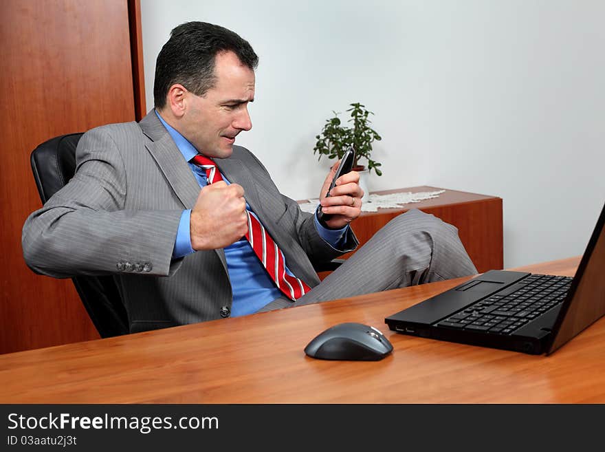 Angry businessman in his office talking on the phone.